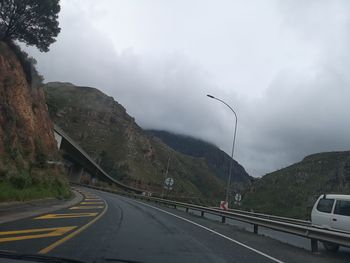 Street by mountain against sky