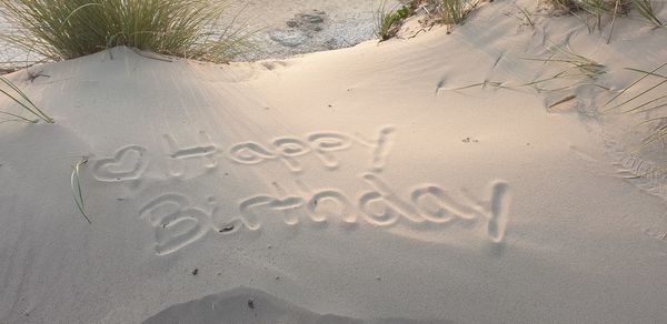 High angle view of text on sand at beach