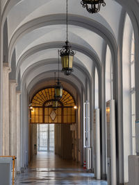 Long interior corridor of a hospital with large windows.