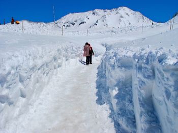 Man on snow covered mountain against sky