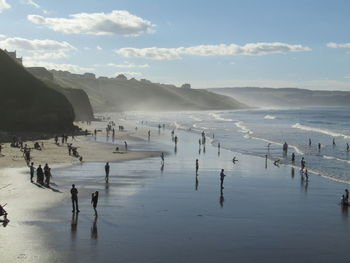 People on beach against sky