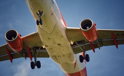 Low angle view of airplane flying against sky
