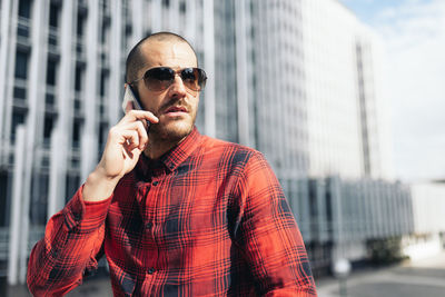 Young man wearing sunglasses standing in city