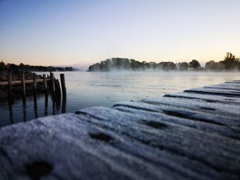 Scenic view of lake against clear sky during sunset