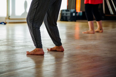 Low section of people standing on hardwood floor