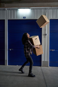 Full length of woman standing against wall