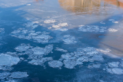 Aerial view of frozen lake against blue sky