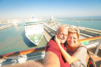 Portrait of senior couple on boat against sky