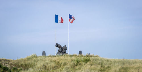 Low angle view of flag on field against sky