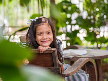 Portrait of smiling girl sitting on seat