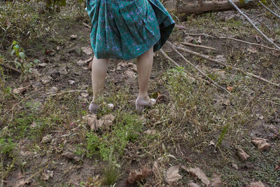 Low section of woman walking on field