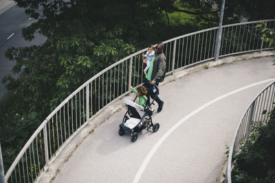 High angle view of father with children walking on bridge over trees