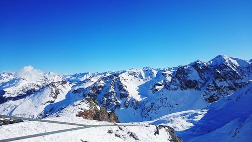 Scenic view of snowcapped mountains against clear blue sky