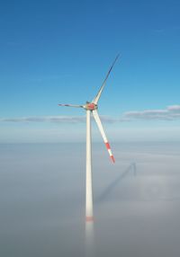 Wind turbine above morning fog