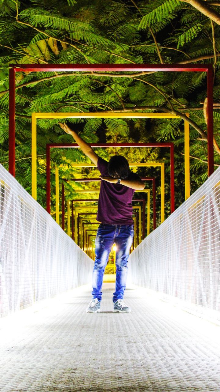 full length, the way forward, one person, bridge - man made structure, casual clothing, real people, lifestyles, leisure activity, footbridge, day, outdoors, tree, childhood, nature, people