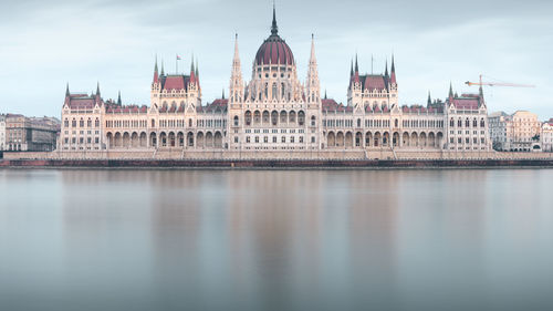 View of historic building by river in city