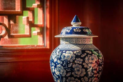 Close-up of vase on red wall