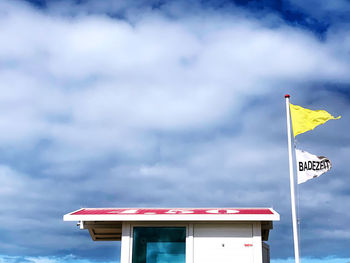 Low angle view of flag against building against sky