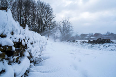 Snow covered field against sky