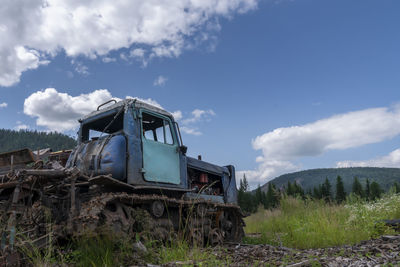 Abandoned truck on field against sky