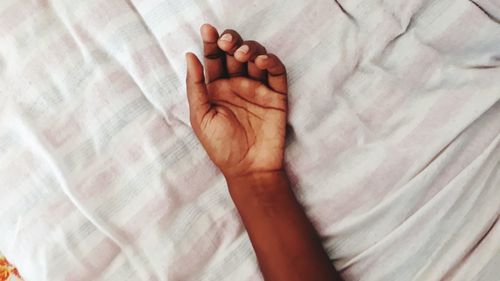 Close-up of baby hand on bed