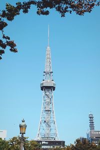 Low angle view of communications tower against clear blue sky