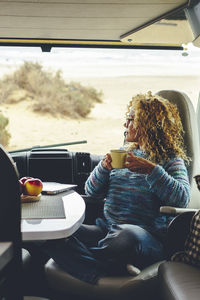 Young woman using mobile phone while sitting in car