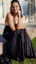 Portrait of a smiling young woman sitting outdoors