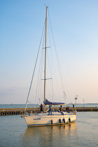 Sailboats moored in sea against clear sky