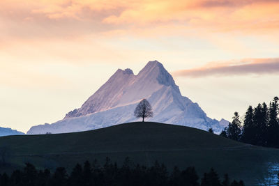 Scenic view of snowcapped mountains against sky during sunset
