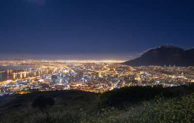 High angle view of illuminated buildings against sky at night