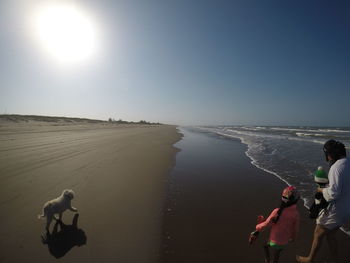 People on beach against clear sky