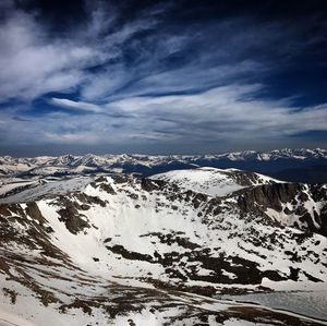 Aerial view of snowcapped mountain against cloudy sky