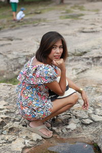 Portrait of woman sitting on rock