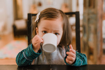 Close-up portrait of girl having drink at home