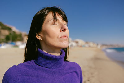 Beautiful happy mature woman enjoying a sunny winter day at the beach