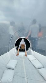 Rear view of woman sitting in corridor