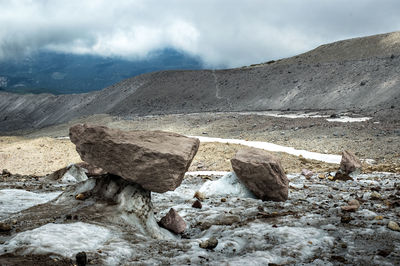 Scenic view of rocky mountains against cloudy sky