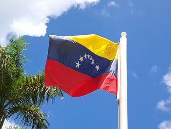 Low angle view of flag against blue sky
