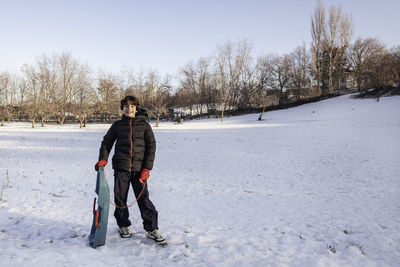 Portrait of man standing on snow covered field during winter