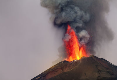 Smoke emitting from volcanic mountain against sky