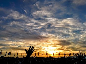 Silhouette people at stadium against sky during sunset