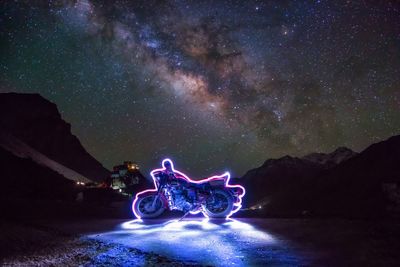 Illuminated motorcycle against star field at night