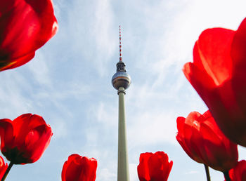 Low angle view of red tower against cloudy sky