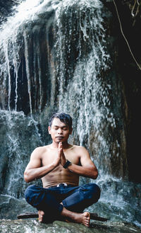 Full length of man sitting on rock