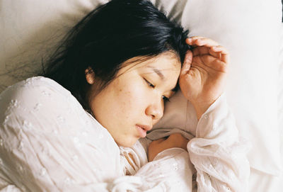 High angle view of woman lying in bed at home