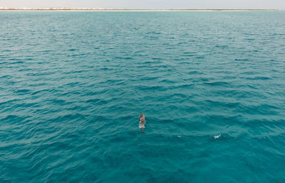 High angle view of person in sea against sky