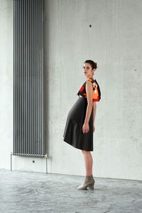 Portrait of young woman standing on wall