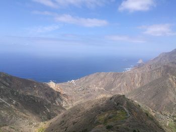 Scenic view of sea and mountains against sky