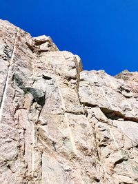 Low angle view of rock formation against clear blue sky